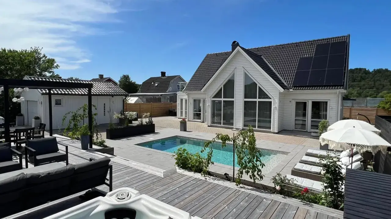 Lyxig altan inspiration med pool, spabad och solstolar. Ett modernt hus med solpaneler.