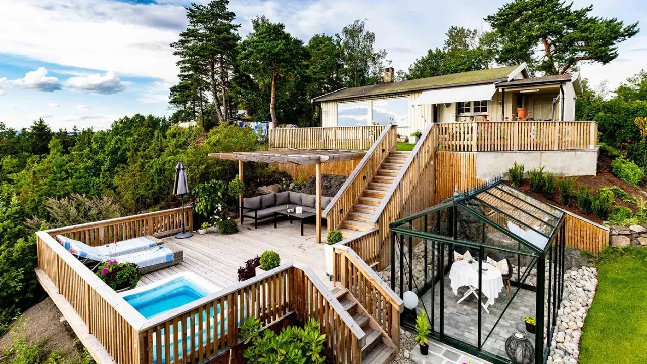 Vacker altan med pool och loungegrupp, perfekt för att skruva trall från sidan och njuta av utsikten. Ett växthus med bord och stolar finns också.