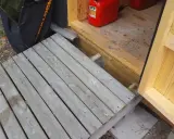 En nybyggd ramp till trappan gör det enklare att komma in i boden. En röd dunk står redo.