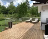 En nybehandlad altan med solstolar och grill, redo för sommarens mys. Snart dags att måla altan för att skydda träet.