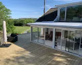 Ny slipad altan med glasveranda och utemöbler. Perfekt för att njuta av sommaren.