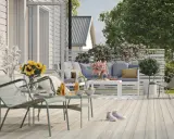 En härlig altan runt huset med bekväma möbler, solrosor och en inbjudande atmosfär för avkoppling.