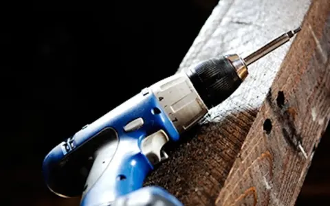 En blå borrmaskin redo att borra i tegel.