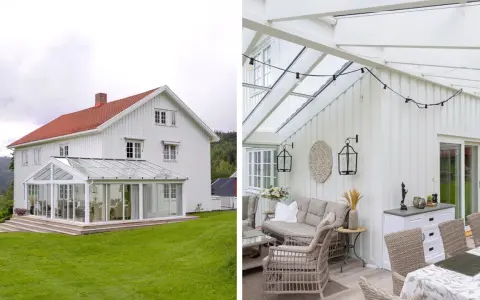 Vitt hus med glasveranda som löper runt husknuten. Utemöbler i rotting och matplats under glastaket.