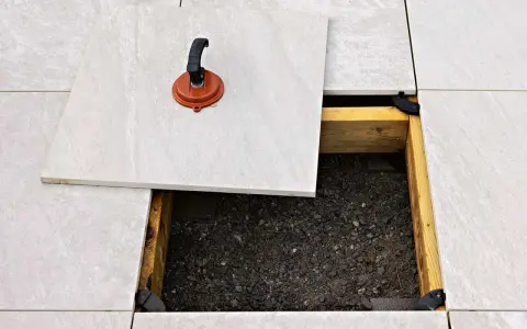 Lättskött klinker runt poolen läggs på en bärande konstruktion. En sugpropp används för att lyfta en platta.