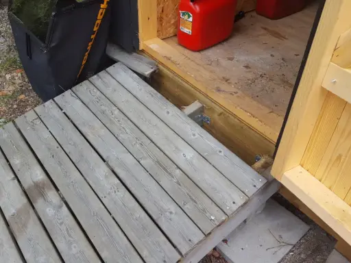 En nybyggd ramp till trappan gör det enklare att komma in i boden. En röd dunk står redo.
