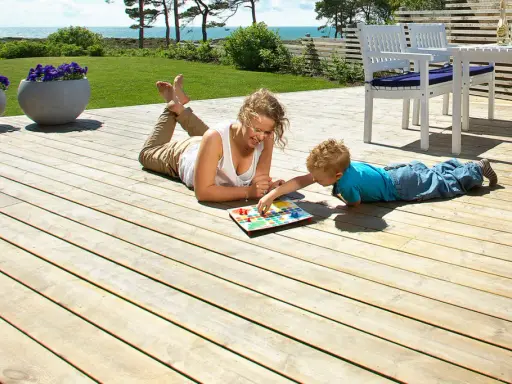 Kvinna och barn spelar spel på en altan med trall tjocklek som ger en stabil yta.