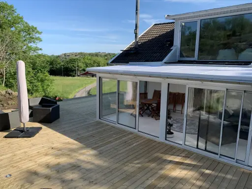 Ny slipad altan med glasveranda och utemöbler. Perfekt för att njuta av sommaren.