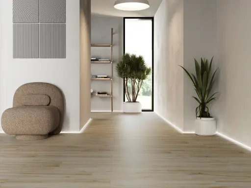 Modern hall med klinker som ger en varm och inbjudande känsla. En bekväm fåtölj och gröna växter skapar en lugn atmosfär.