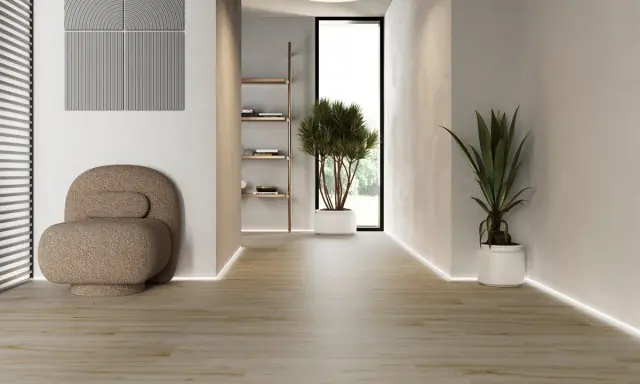 Modern hall med klinker som ger en varm och inbjudande känsla. En bekväm fåtölj och gröna växter skapar en lugn atmosfär.