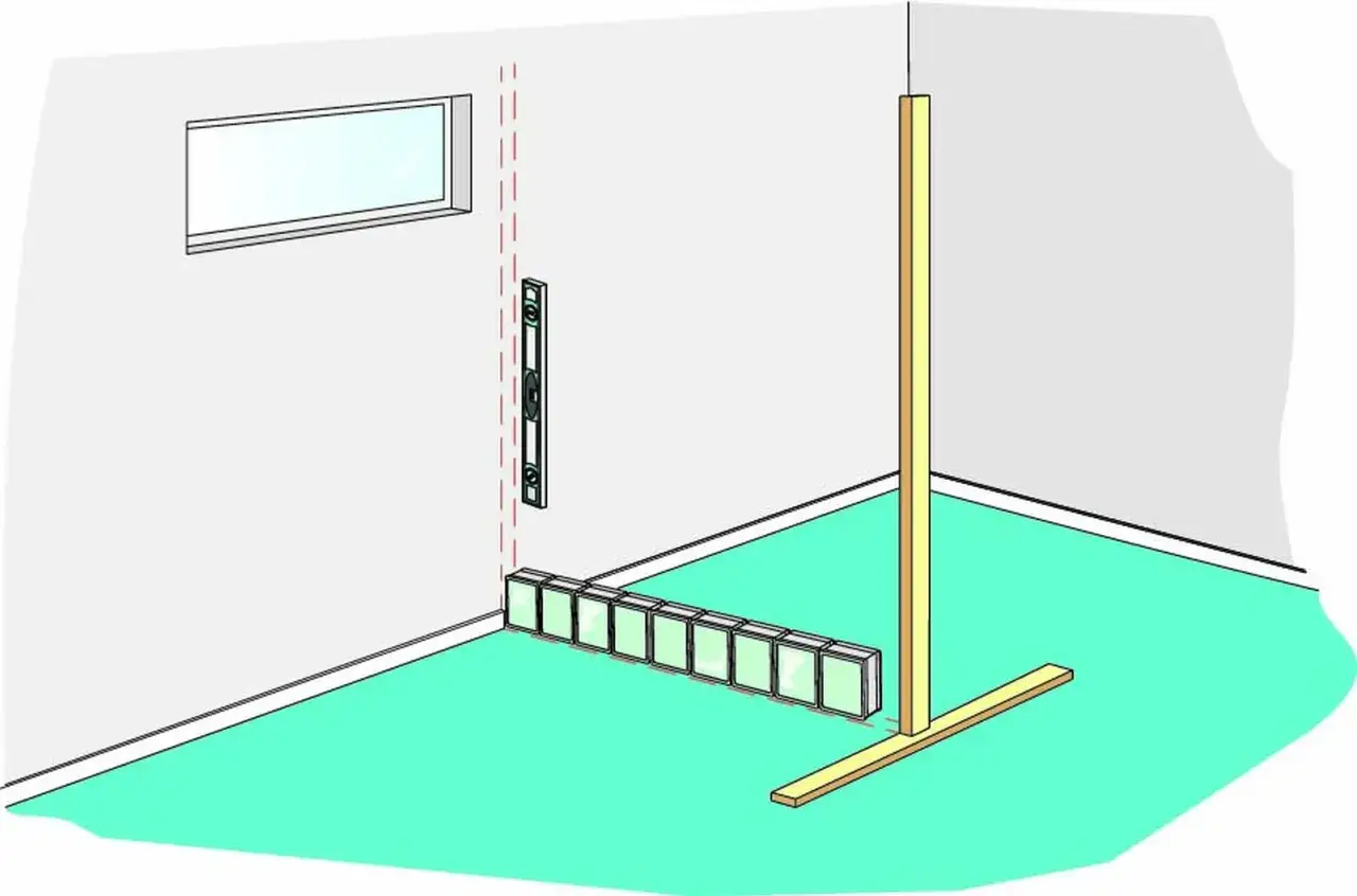 Byggnation av en v&auml;gg med mura glasblock. En vattenpass visar att det &auml;r rakt.