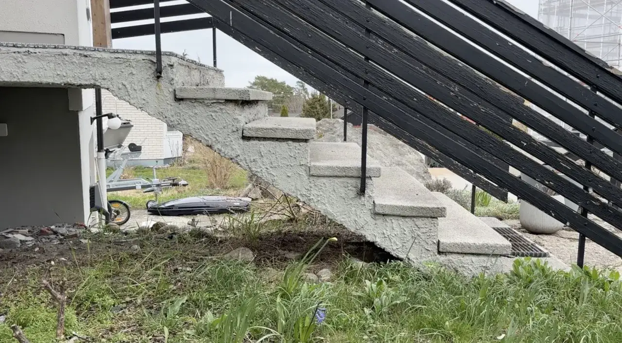 Betongtrappa med svarta räcken, redo för att gjuta trappsteg. En trailer och takbox syns i bakgrunden.