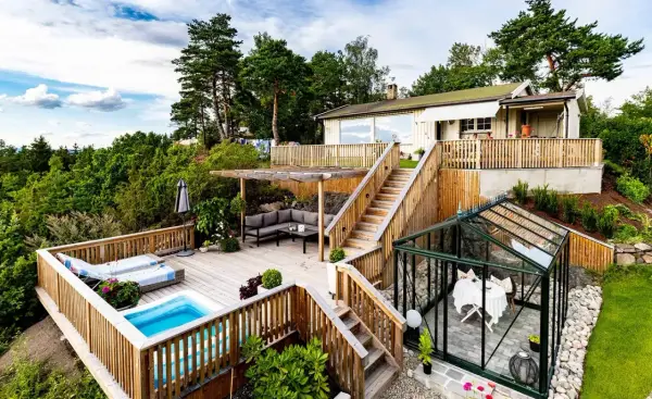Vacker altan med pool och loungegrupp, perfekt för att skruva trall från sidan och njuta av utsikten. Ett växthus med bord och stolar finns också.